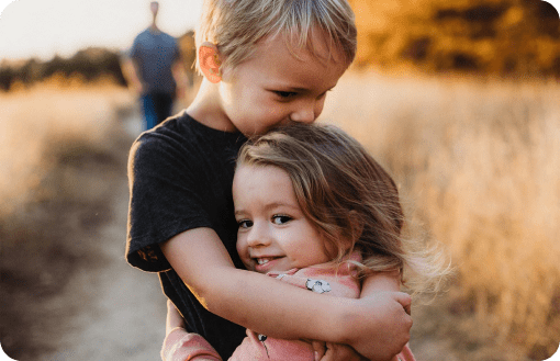 Un frère et une sœur se prenant dans les bras